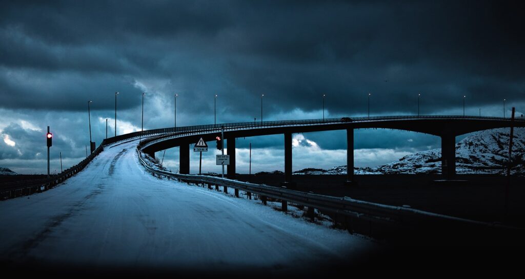 Norwegische Brücke im Winter nahe Sommarøy mit düsterer Stimmung und Roadtrip-Atmosphäre in Nordnorwegen