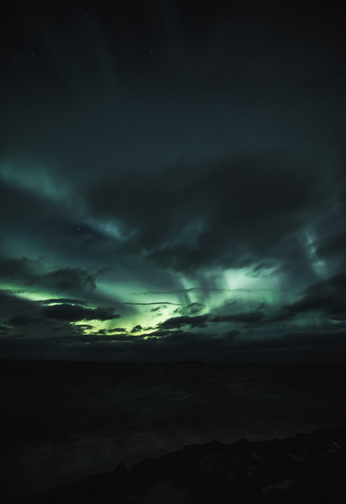 Nordlichter über Senja in Nordnorwegen, mit leichter Bewölkung und sichtbaren Sternen