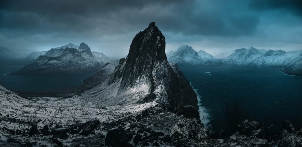 Der Segla auf Senja im Winter — vom Hesten aus fotografiert, dunkle Wolken über dem schneebedeckten Fels.