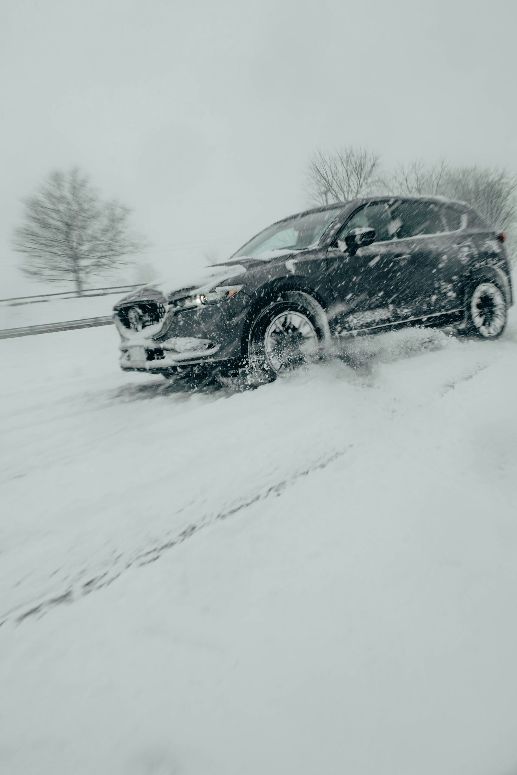 Mietwagen fährt durch verschneite norwegische Landschaft – zuverlässig unterwegs trotz eisiger Straßen und winterlicher Extrembedingungen.