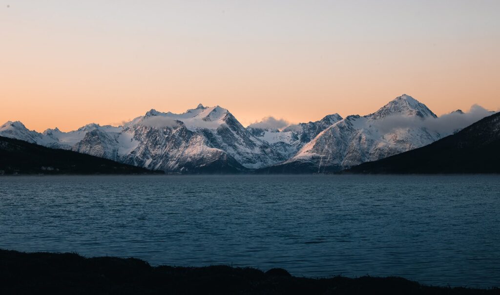 Lyngenfjord im sanften Winterlicht mit verschneiten Bergen und ruhigem Wasser