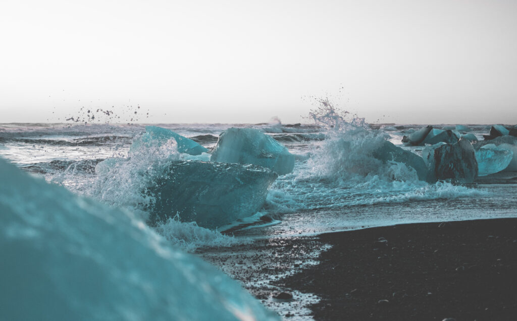 Diamond Beach in Island mit Eisblöcken am schwarzen Strand und Wellen, die an den Uferrand schlagen
