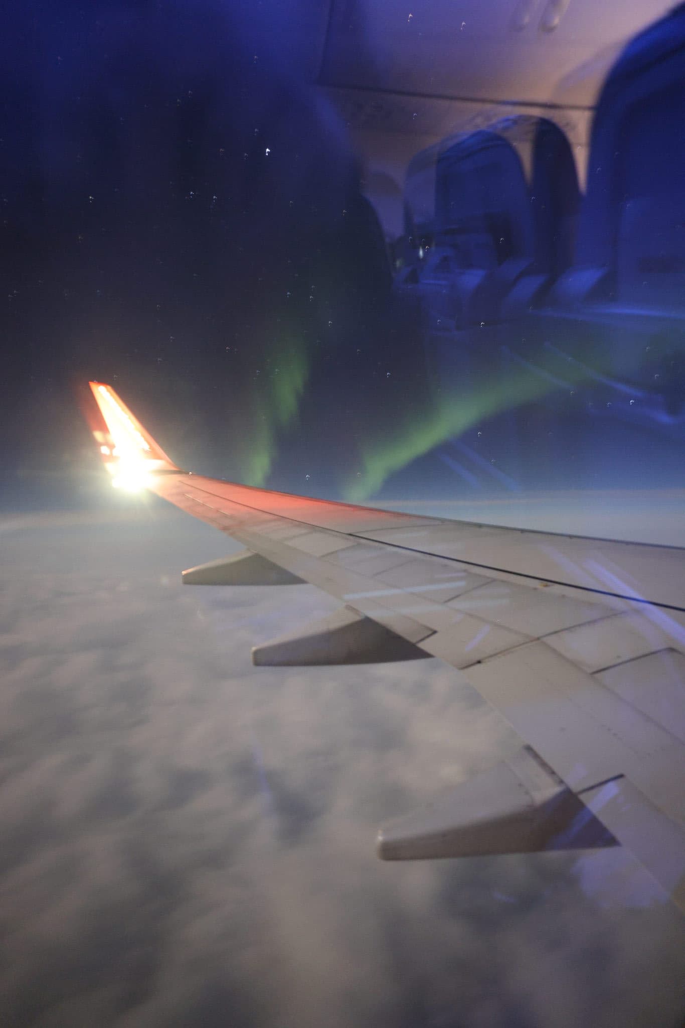 Grünes Nordlicht über der Tragfläche beim Anflug auf Tromsø